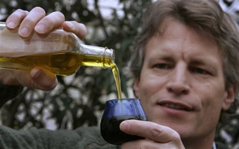 Dan Flynn, executive director of the University of California, Davis, Olive Center, pours olive oil into a sampling glass at the Davis, Calif. Researchers found 69 percent of imported oils and ten percent of domestic oils sampled did not meet the international standards for the extra virgin title.